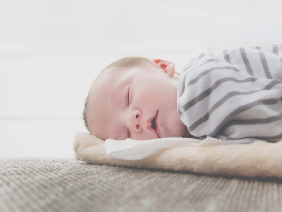 Een baby slaapt rustig op een zacht dekentje